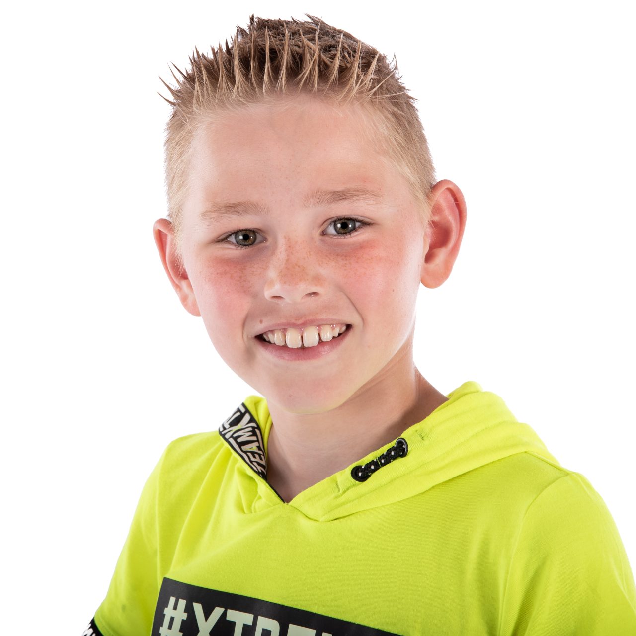 Lachende jongen in een neongele hoodie tegen een witte achtergrond