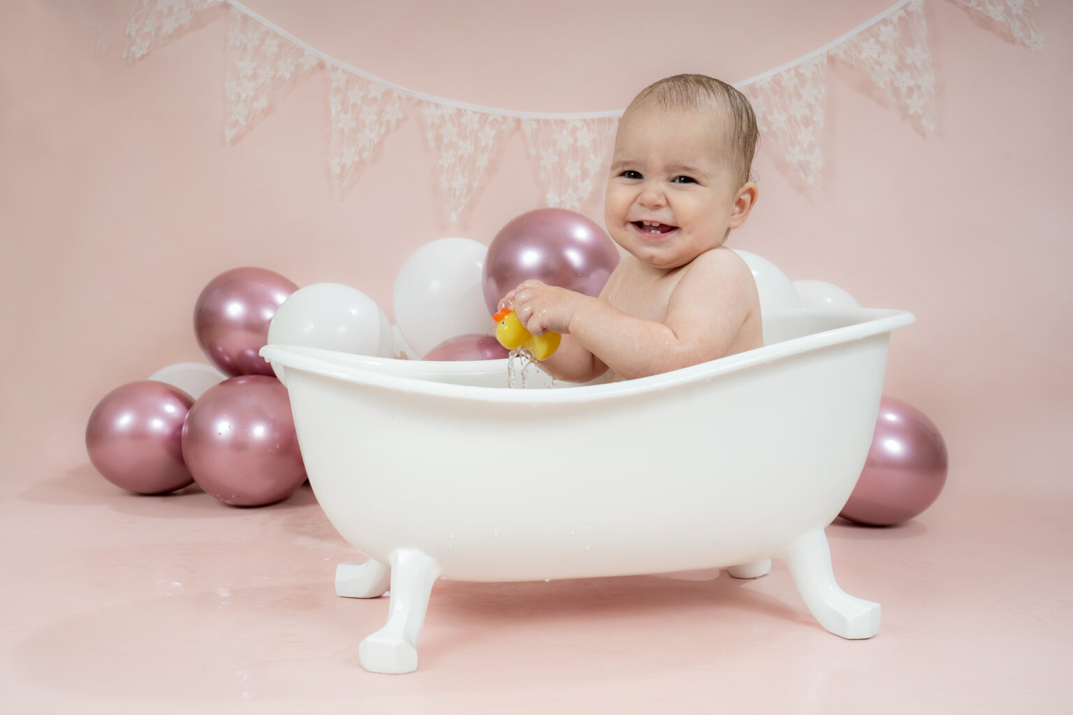 Baby speelt met een eendje in het badje na de cakesmash