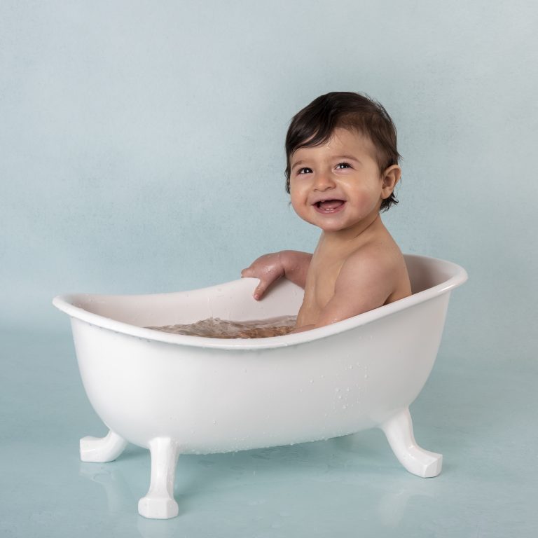 Lachende baby in een badkuipje na de cakesmash