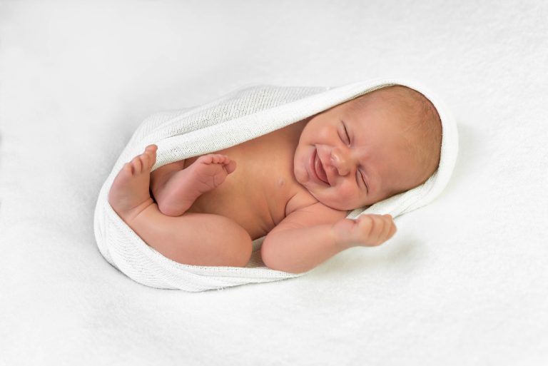 Lachende baby van een paar maanden oud tijdens een fotoshoot in de studio