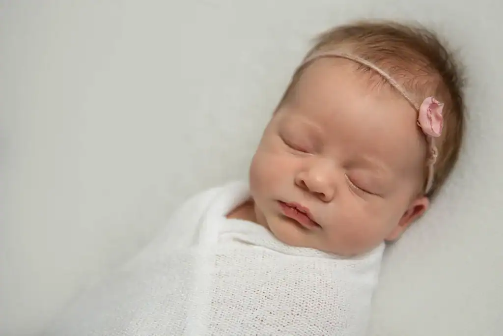 Pasgeboren baby slaapt ingebakerd tijdens een newborn shoot